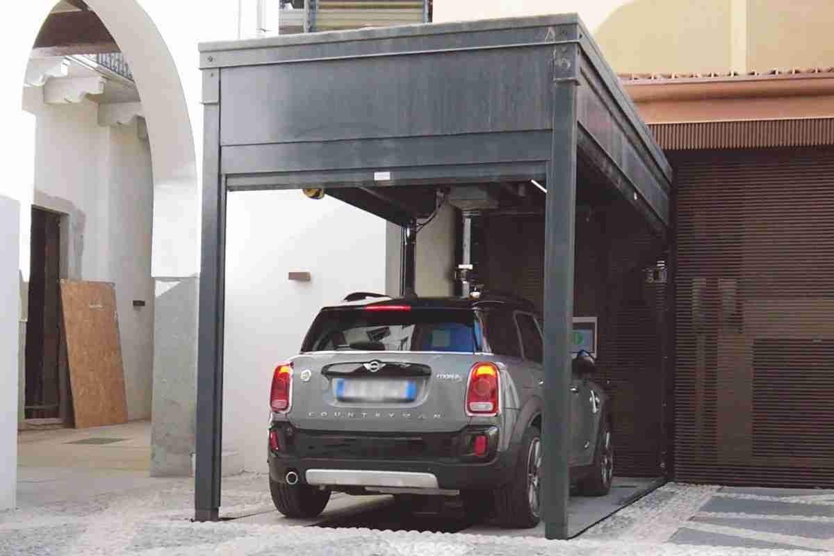 Graues Auto unter grauer Metallstruktur mit Dach geparkt, Innenhof mit Wohngebäuden